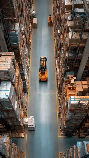 Forklift driving in warehouse shelf aisle.webp
